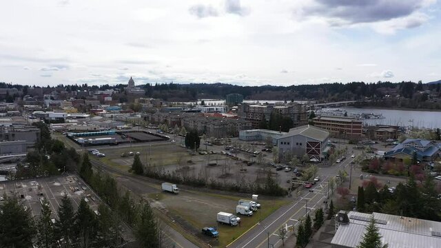 Cinematic rise and reveal aerial drone footage of downtown Olympia, the Olympia Farmers Market, Percival Landing Park, West Bay and a view of Historic District, Capitol building in Olympia, Washington