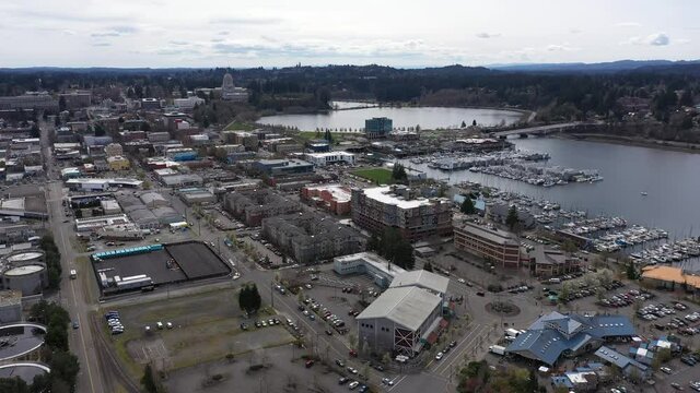 Cinematic bird's-eye footage of downtown Olympia, the Olympia Farmers Market, Percival Landing Park, West Bay with a panoramic view of Historic District, Capitol building in Olympia, Washington