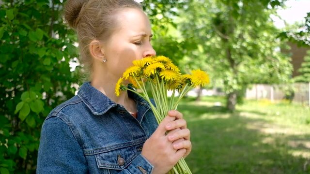 Young woman sneezing with bouquet of flowers. Concept: seasonal allergy.
