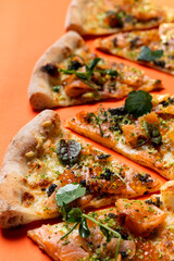 Slices of smoked salmon pizza placed in a row, close up