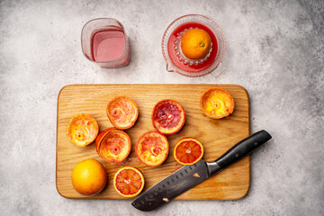 sliced Sicilian Blood oranges and freshly squeezed juice with manual juicer squeezing . High quality photo