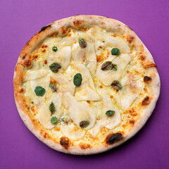 Whole round pizza with pear and gorgonzola cheese, gourmet pizza in bright background