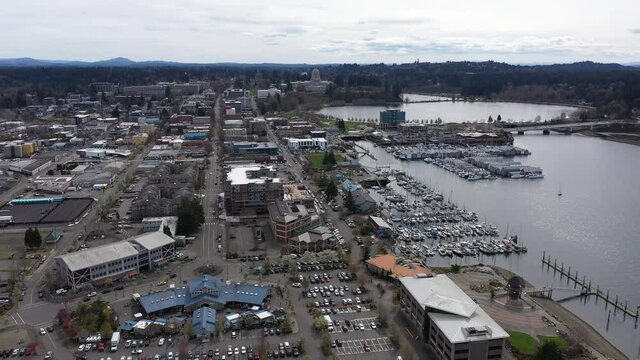 Orbiting cinematic drone footage of downtown Olympia, the Olympia Farmers Market, Percival Landing Park, West Bay with a panoramic view of Historic District, Capitol building in Olympia, Washington