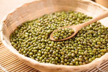 Mung bean seeds in wooden spoon and bamboo basket, Food ingredients in Asian cuisine and produce mung bean sprout