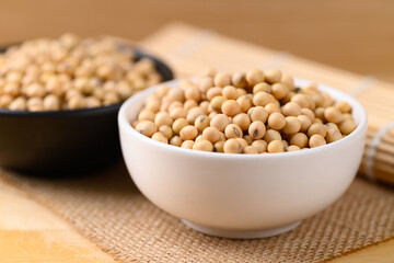 Soybean seeds in a bowl on wooden background