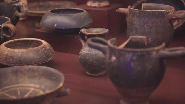 etruscan pottery and tableware in clay in archeology museum, Populonia, panning