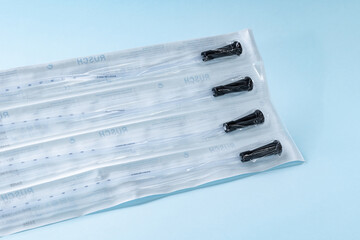 Rusch male and female all purpose catheter on blue background, straight tipped intermittent...