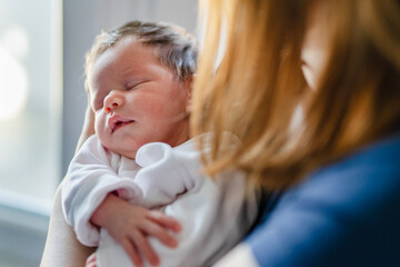 Close up on newborn baby girl in hands of her mother motherhood bonding concept