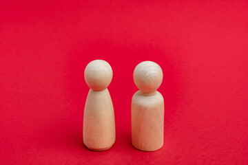 Wooden figurines of man and woman on red backdrop, relationship, communication problems. Happy couple concept