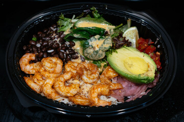 Mexican style meal with shrimp, salad, avocado, bean, ham and rice  