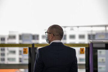 Young asian businessman standing at platform skytrain station. Businessman in urban city travel by sky train.