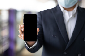 Close up male hand using smartphone and travel by sky train in train station.