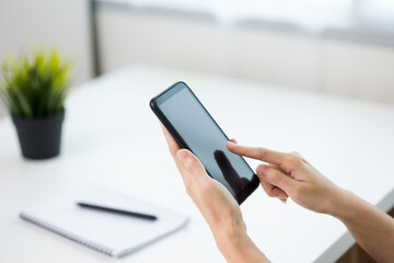 Close up business woman hands using smartphone. Young female texting touching on display of cell phone.