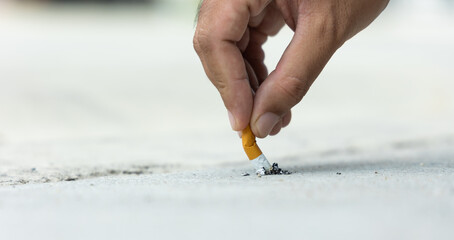 Close up hand putting out a cigarette. man extinguished his cigarette by crushing the floor. He...