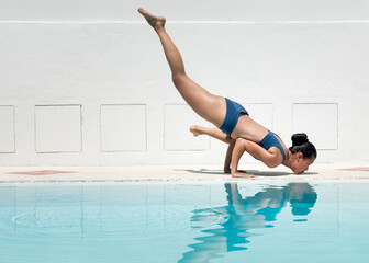 Asian woman relaxing in doing yoga near pool on a sunny day  with beautiful Feeling comfortable and relax in holiday,Vacations Concept