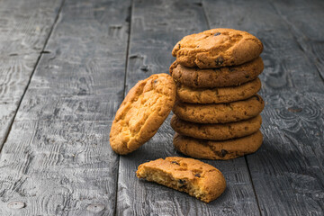 Cookies with cereal and chocolate on a black wooden table.