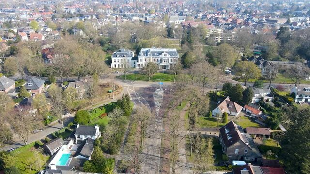 Flying towards large mansion at the end quiet road in small town