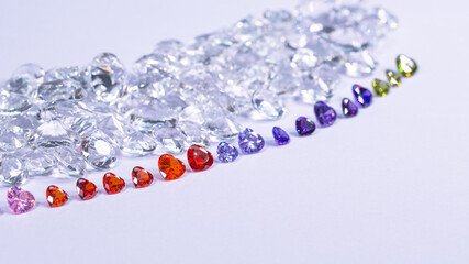 colorful diamond in heart shape are placed in a row on white diamonds background,