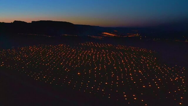Aerial view of Candles burning to heat up the Vineyards in Chablis, France during sunrise.