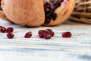 Pomegranates in a basket and on the table on a wooden background.