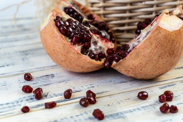 Pomegranates in a basket and on the table on a wooden background.