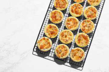 Mini pie from meat and mushrooms in metal tray on marble background