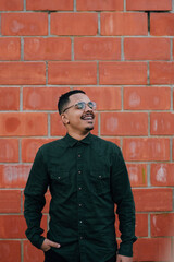 portrait of male model with green military t-shirt on brick wall