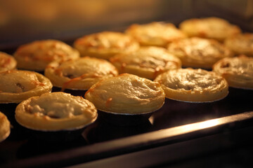 Mini pie from meat and mushrooms baking in industrial oven