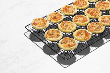 Mini pie from meat and mushrooms in metal tray on marble background