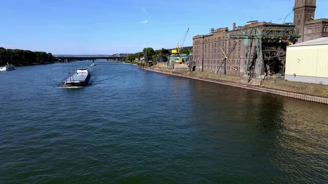 Aerial drone shot of boat and industrial area along Rhine River in Lahnstein, Germany.