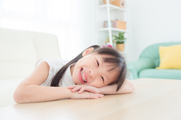 Obraz na płótnie Canvas Little asian girl smiling happily in living room .