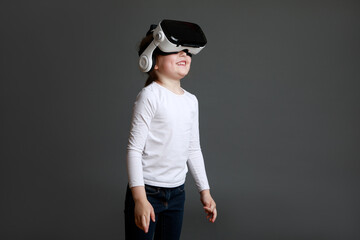 Child experiencing virtual reality on grey background