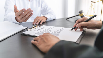 Lawyer preparing to sign a contract reading documents at meeting