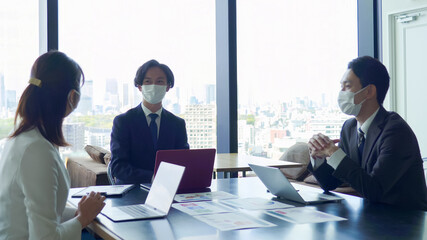 マスクをして打ち合わせをするビジネスマン