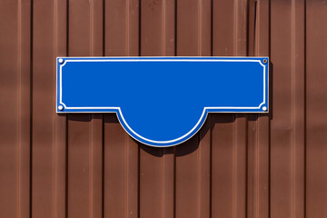 A blue address sign on the fence of a private house.