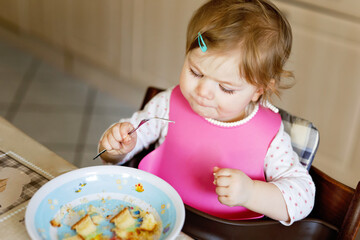 Adorable baby girl eating from spoon mashed vegetables and puree. food, child, feeding and people...