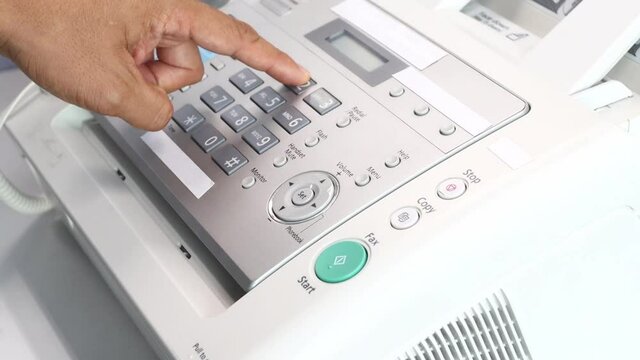hand man using a fax machine in the office, equipment for data transmission