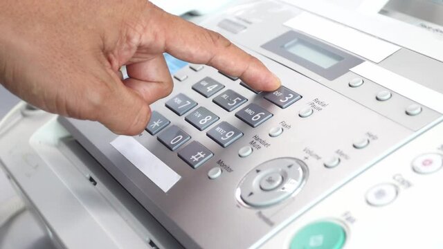 hand man using a fax machine in the office, equipment for data transmission