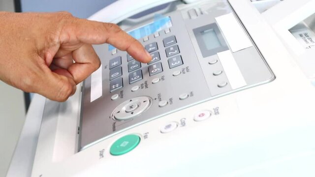 hand man using a fax machine in the office, equipment for data transmission