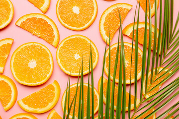 Pieces of fresh oranges with tropical leaf on color background