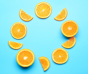 Frame made of cut fresh oranges on color background