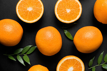Fresh oranges with green leaves on dark background