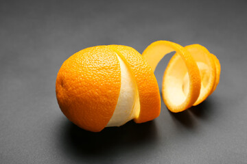 Fresh orange with peel on dark background