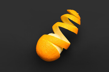 Fresh orange with peel on dark background
