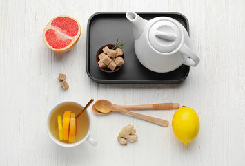 Composition with tasty ginger tea and ingredients on light wooden background