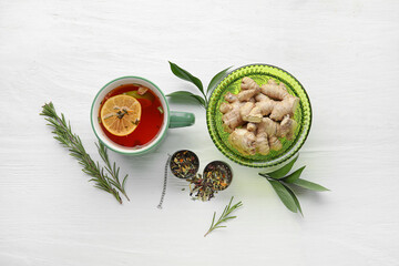 Composition with cup of tasty ginger tea and ingredients on light background