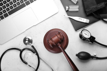 Judge gavel, laptop, stethoscope and sphygmomanometer on light background. Concept of health care...