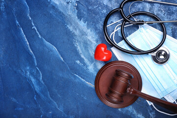 Judge gavel, masks, heart and stethoscope on color background. Concept of health care reform