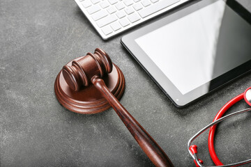 Judge gavel, tablet computer, keyboard and stethoscope on grey background. Concept of health care...