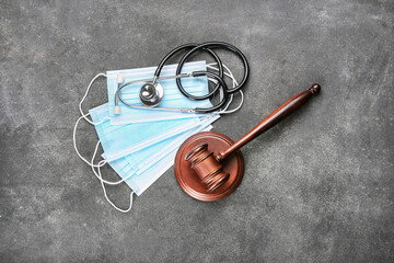Judge gavel, masks and stethoscope on grey background. Concept of health care reform
